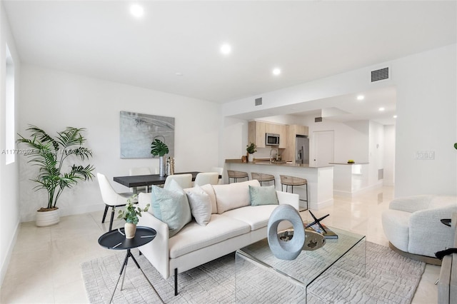 living area with light tile patterned flooring, baseboards, visible vents, and recessed lighting