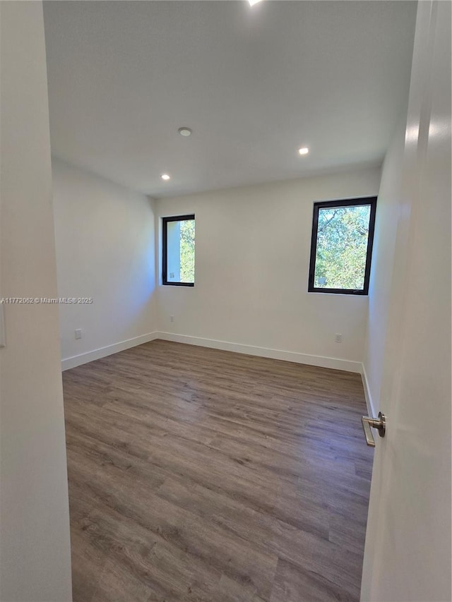 unfurnished room with baseboards, recessed lighting, and dark wood finished floors