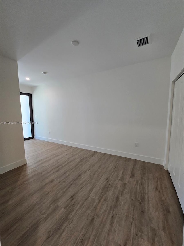 empty room featuring visible vents, baseboards, and wood finished floors