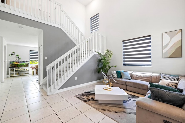 23703 SW 116th Ct, Homestead, FL 33032 - living room featuring baseboards, stairway, a high ceiling, and tile patterned flooring