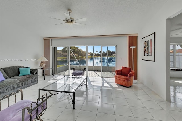 3881 Hidden Cypress Way, Lake Worth, FL 33467 - living room featuring ceiling fan, plenty of natural light, a water view, a textured ceiling, and light tile patterned floors