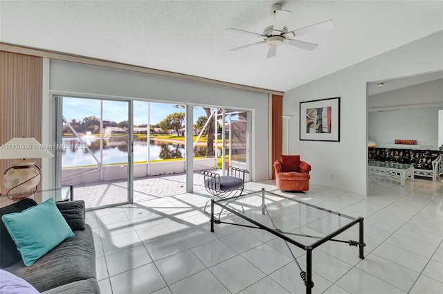3881 Hidden Cypress Way, Lake Worth, FL 33467 - living area with lofted ceiling, a ceiling fan, tile patterned floors, a water view, and a textured ceiling