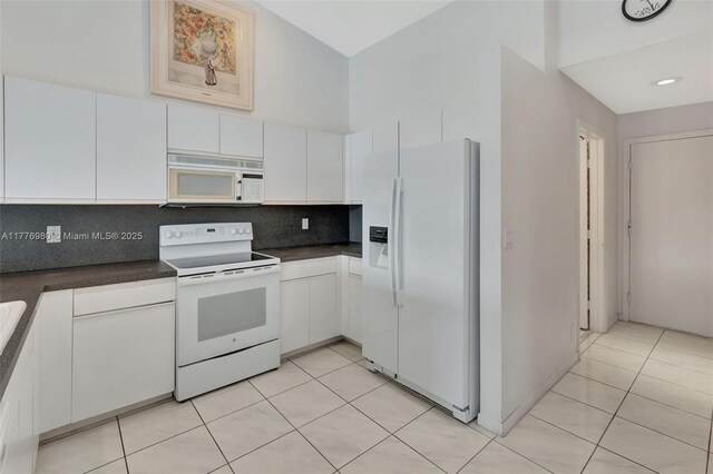3881 Hidden Cypress Way, Lake Worth, FL 33467 - kitchen with white appliances, dark countertops, decorative backsplash, white cabinetry, and high vaulted ceiling