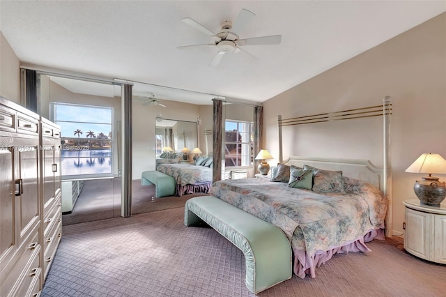 3881 Hidden Cypress Way, Lake Worth, FL 33467 - bedroom with light carpet, multiple windows, a ceiling fan, a water view, and lofted ceiling