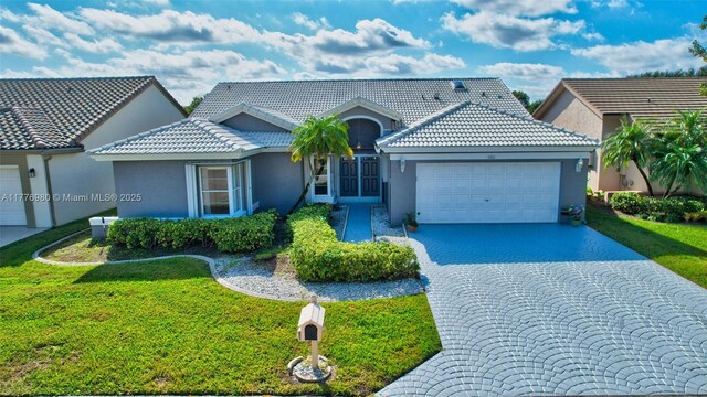 3881 Hidden Cypress Way, Lake Worth, FL 33467 - view of front of house with stucco siding, an attached garage, and a front lawn