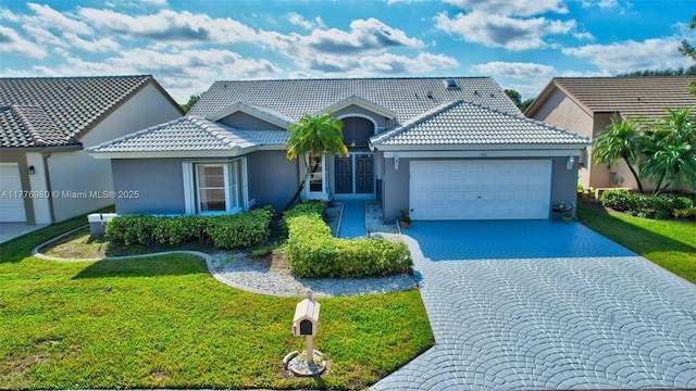 3881 Hidden Cypress Way, Lake Worth, FL 33467 - view of front of house with stucco siding, an attached garage, and a front lawn