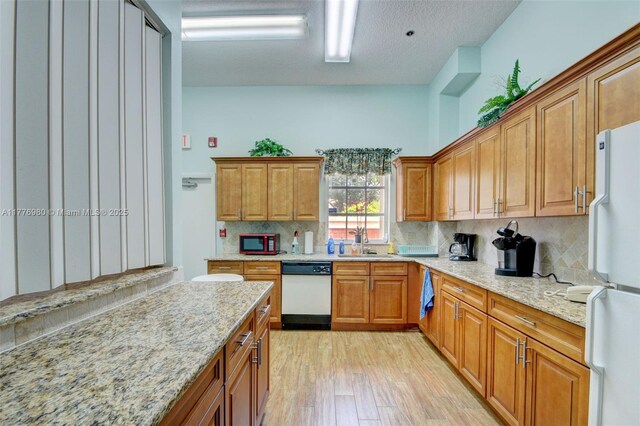 3881 Hidden Cypress Way, Lake Worth, FL 33467 - kitchen featuring white appliances, a sink, tasteful backsplash, light wood-style floors, and light stone countertops
