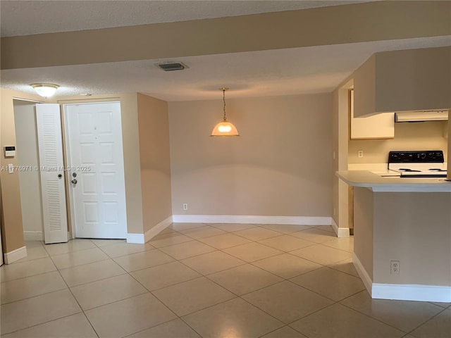 kitchen featuring electric range, light countertops, light tile patterned floors, and visible vents