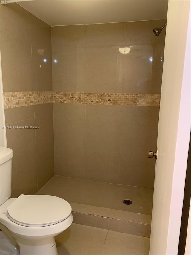 bathroom featuring toilet and a stall shower