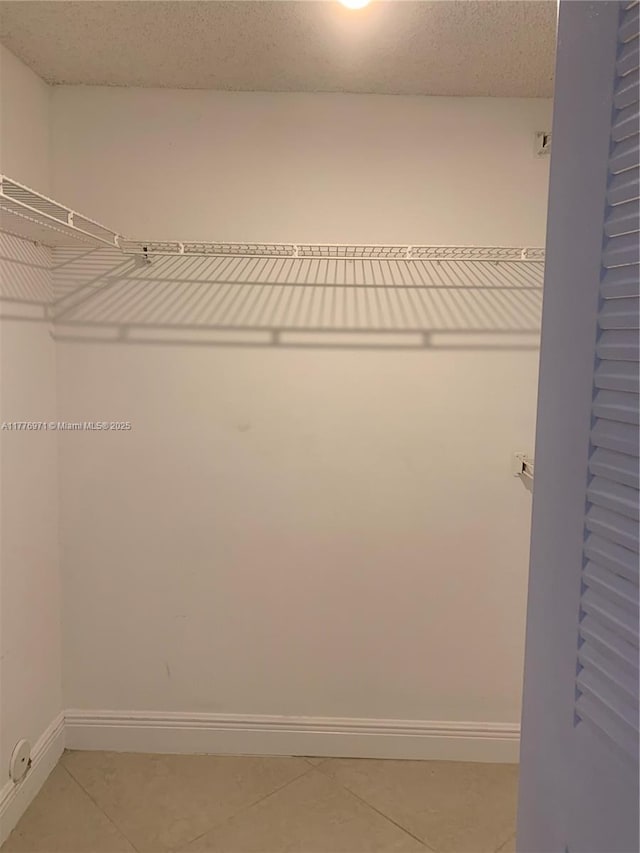 spacious closet with light tile patterned floors