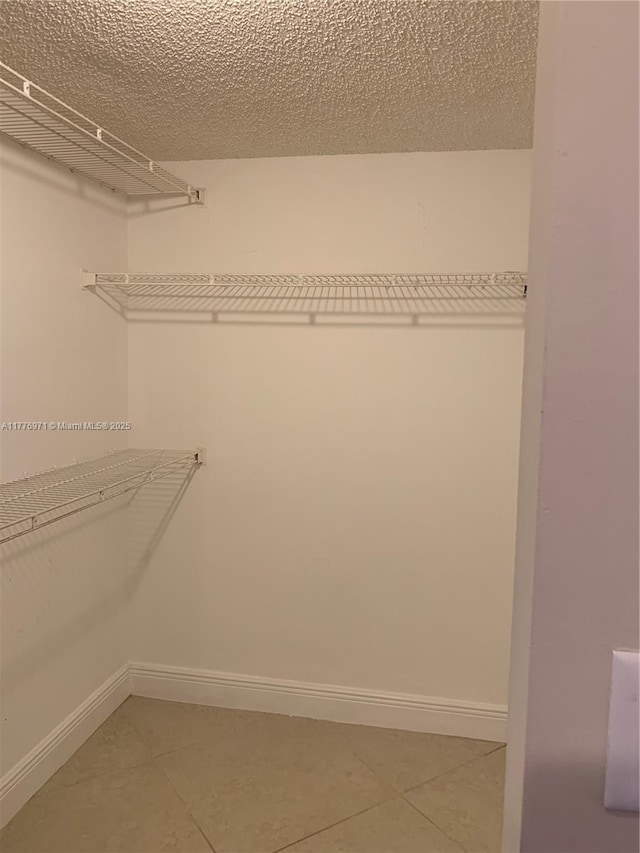 walk in closet with light tile patterned floors