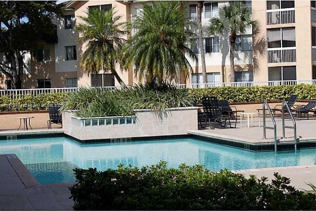 pool with fence and a patio area