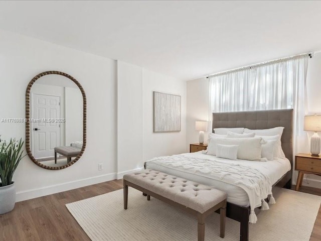 bedroom with baseboards and wood finished floors