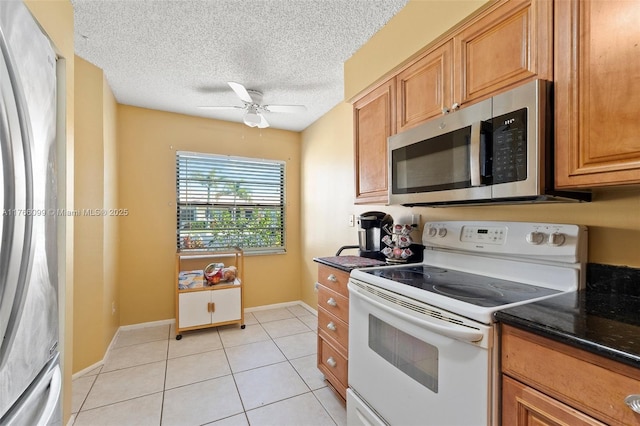 6034 Indrio Rd Unit 7, Fort Pierce, FL 34951 - kitchen featuring light tile patterned floors, a textured ceiling, brown cabinetry, ceiling fan, and appliances with stainless steel finishes