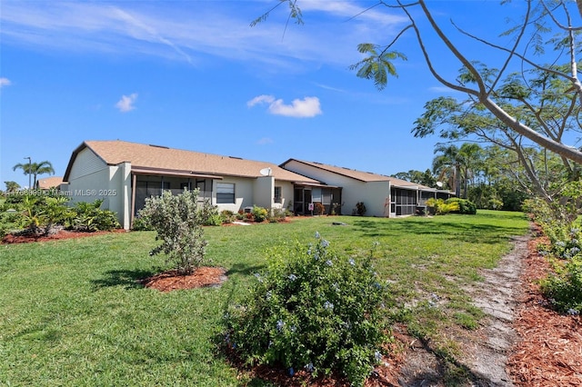 6034 Indrio Rd Unit 7, Fort Pierce, FL 34951 - back of property with a sunroom, stucco siding, and a lawn