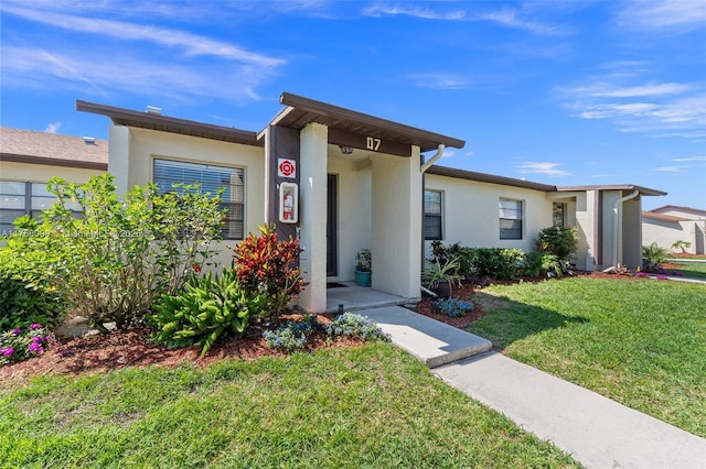 6034 Indrio Rd Unit 7, Fort Pierce, FL 34951 - view of front of house with stucco siding and a front lawn