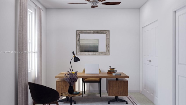 carpeted office space featuring ceiling fan and baseboards