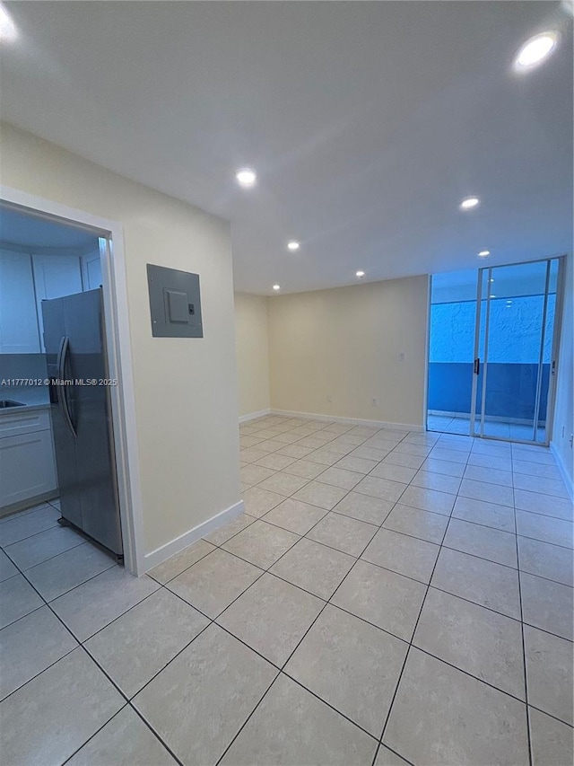 empty room featuring electric panel, recessed lighting, and light tile patterned floors