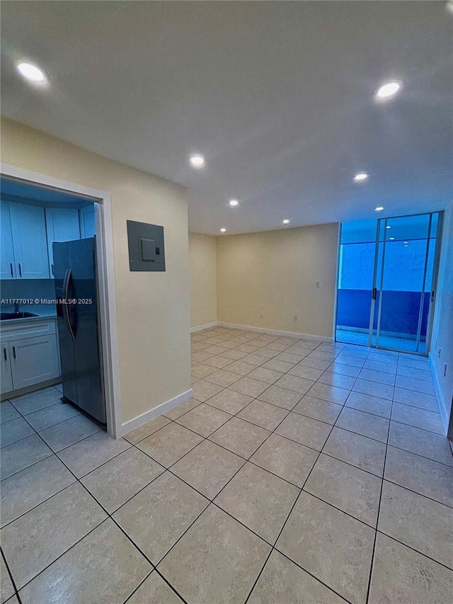 spare room featuring recessed lighting, a sink, electric panel, and light tile patterned floors