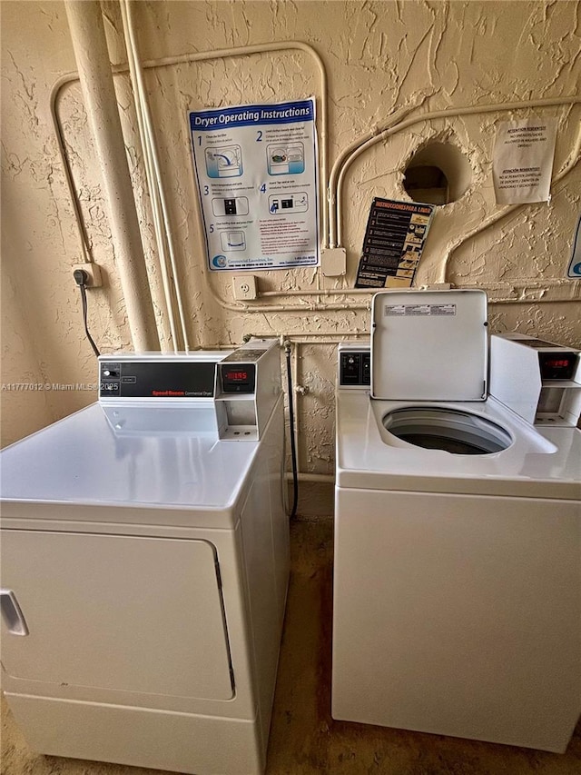community laundry room with washing machine and clothes dryer and a textured wall