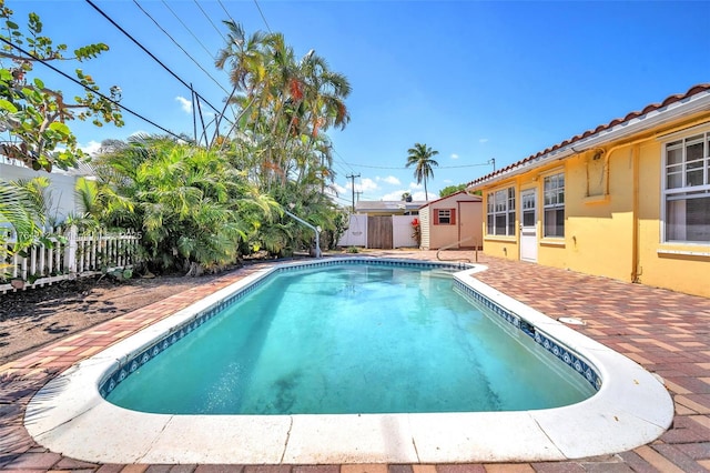 1910 NE 56th St, Fort Lauderdale, FL 33308 - view of pool with a fenced backyard, a storage shed, a patio area, and an outbuilding