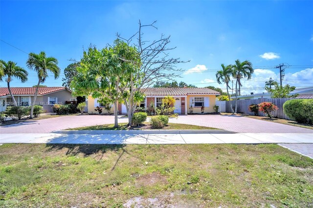 1910 NE 56th St, Fort Lauderdale, FL 33308 - single story home with decorative driveway, a tile roof, and stucco siding