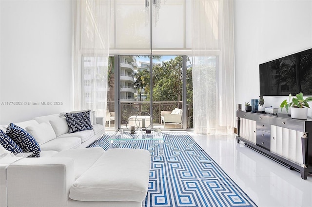 tiled living area featuring floor to ceiling windows and a towering ceiling