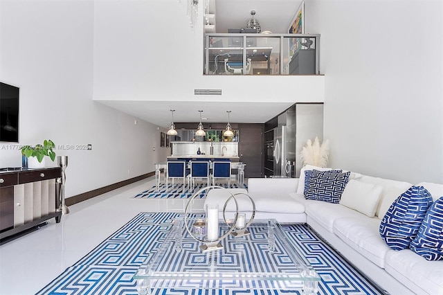 living area with visible vents and a high ceiling