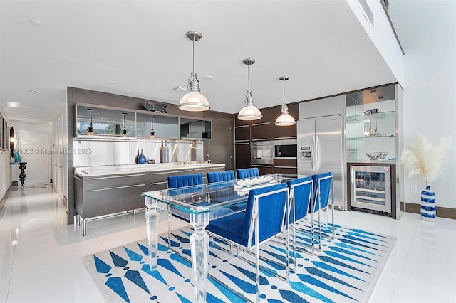 kitchen with beverage cooler, appliances with stainless steel finishes, light tile patterned flooring, and modern cabinets