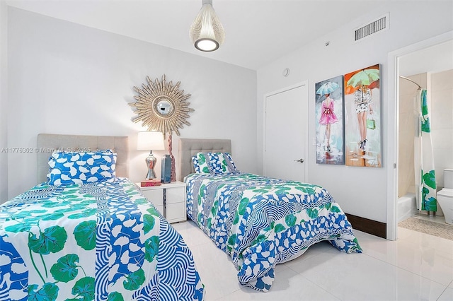 tiled bedroom with visible vents and connected bathroom