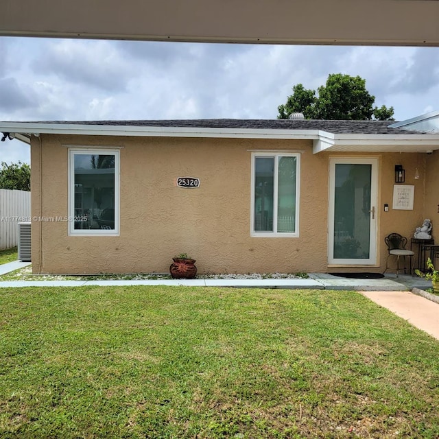 view of front of property featuring stucco siding and a front lawn