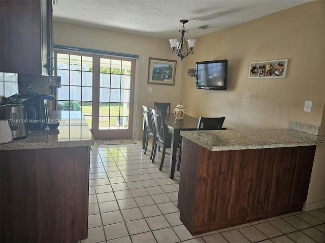 dining room with light tile patterned floors, visible vents, a notable chandelier, and a textured ceiling