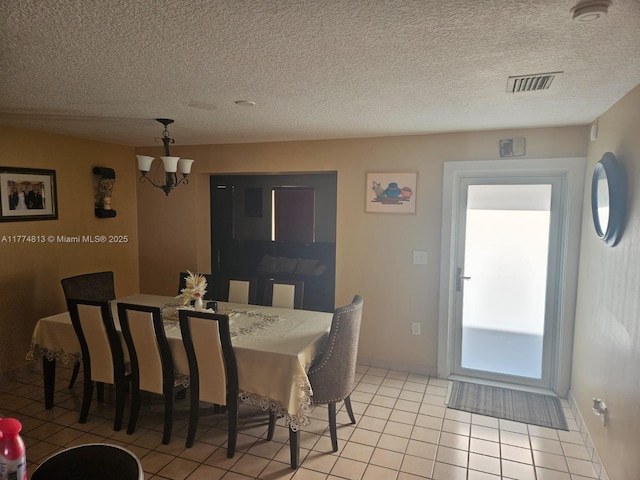 dining area featuring baseboards, a textured ceiling, visible vents, and light tile patterned floors