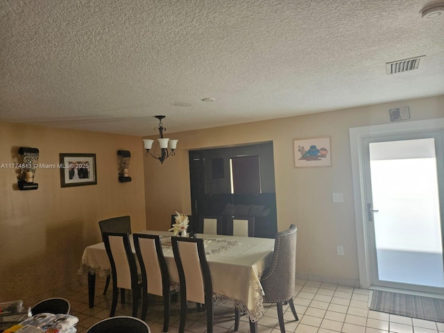 dining area featuring a textured ceiling, visible vents, baseboards, an inviting chandelier, and light tile patterned floors