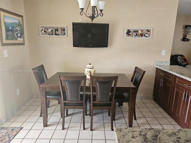 dining space featuring light tile patterned flooring, baseboards, and an inviting chandelier