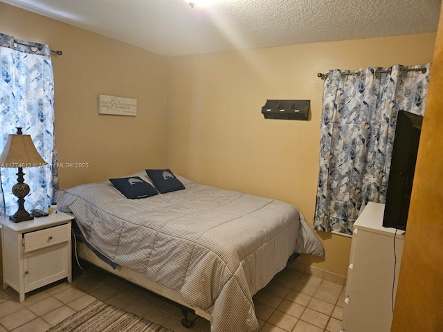 bedroom with a textured ceiling and light tile patterned floors