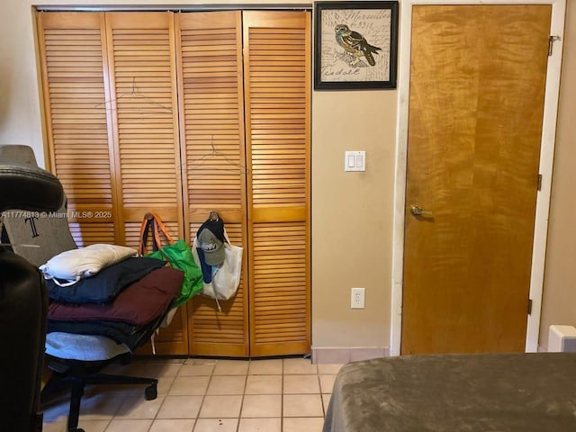 bedroom with light tile patterned flooring and a closet
