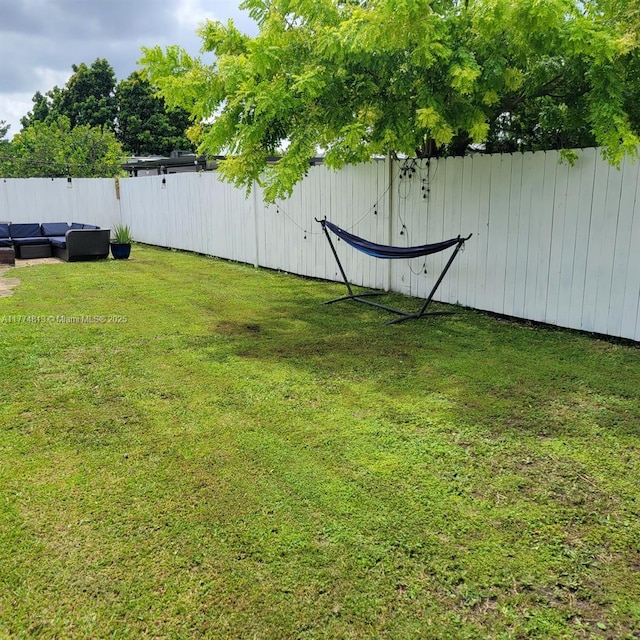 view of yard with an outdoor living space and fence