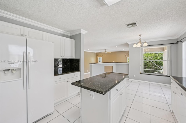 9145 Picot Ct, Boynton Beach, FL 33472 - kitchen featuring white refrigerator with ice dispenser, a kitchen island, ornamental molding, white cabinets, and light tile patterned floors
