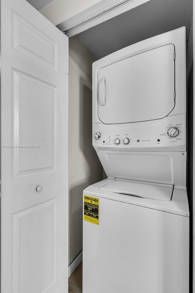 laundry room featuring stacked washer / drying machine and laundry area