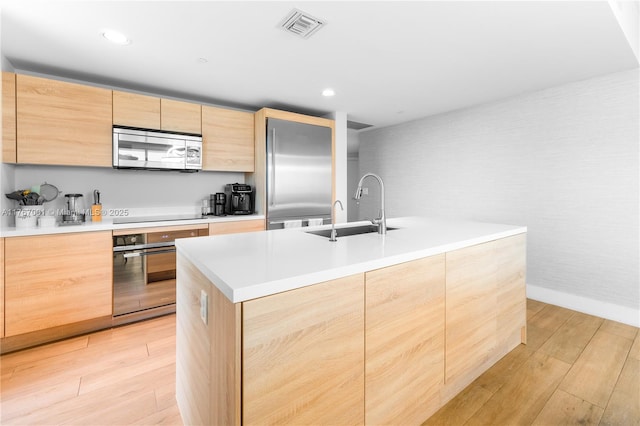 16385 Biscayne Blvd Unit 707, North Miami Beach, FL 33160 - kitchen with black appliances, a sink, light brown cabinets, light wood-style flooring, and modern cabinets