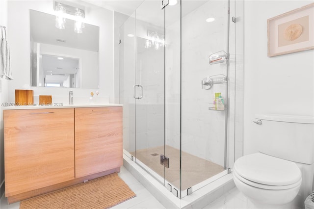 bathroom featuring vanity, a stall shower, and toilet