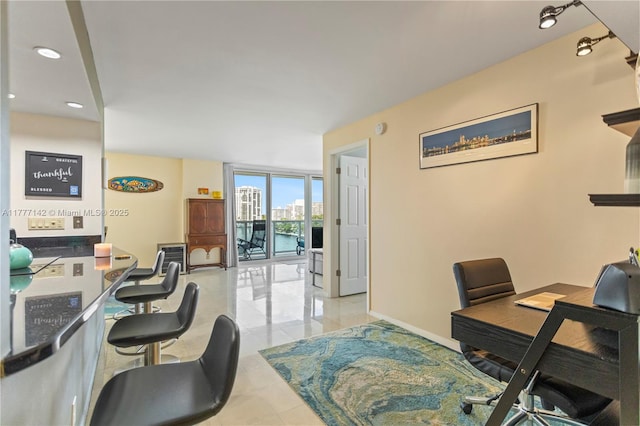 office space with baseboards, recessed lighting, and expansive windows