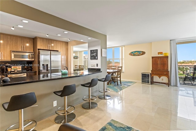 dining room featuring wine cooler, tile patterned floors, an inviting chandelier, and baseboards