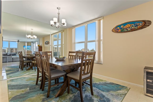tiled dining room with a notable chandelier, beverage cooler, and baseboards