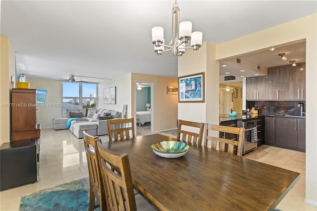 dining space featuring ceiling fan with notable chandelier, light tile patterned floors, and baseboards