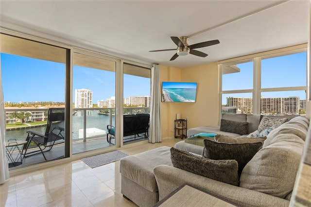 living area with a water view, ceiling fan, and floor to ceiling windows