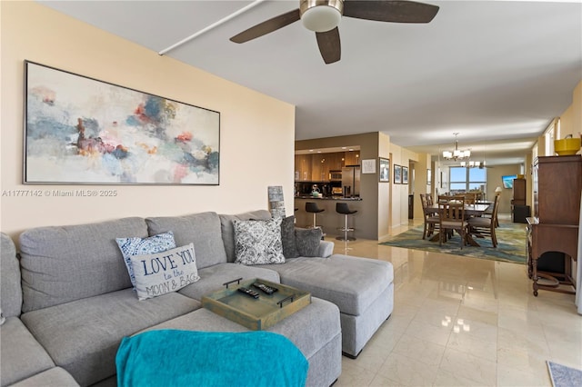 living room with ceiling fan with notable chandelier
