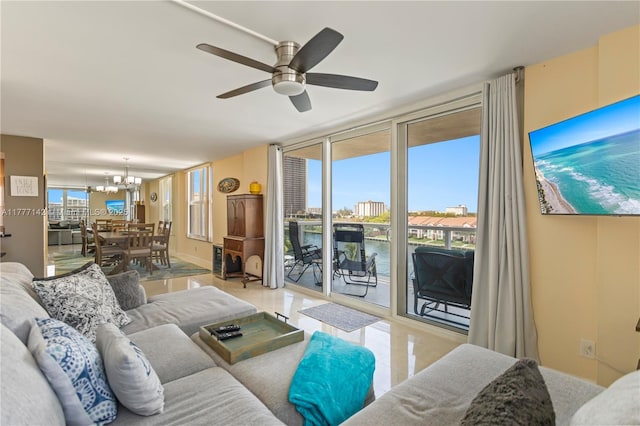 living room with ceiling fan with notable chandelier and floor to ceiling windows