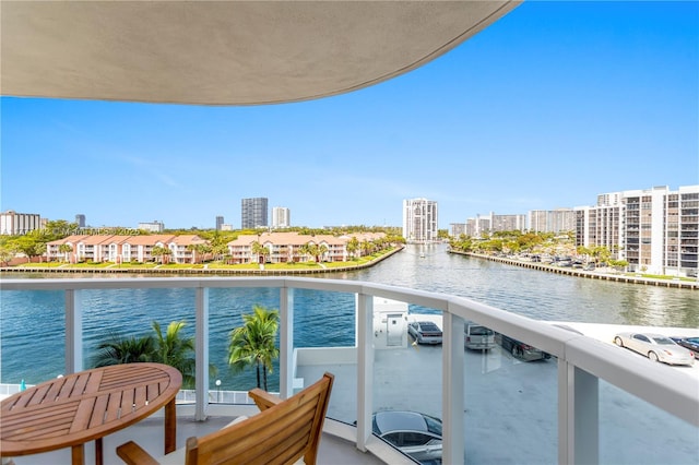 balcony featuring a water view and a city view